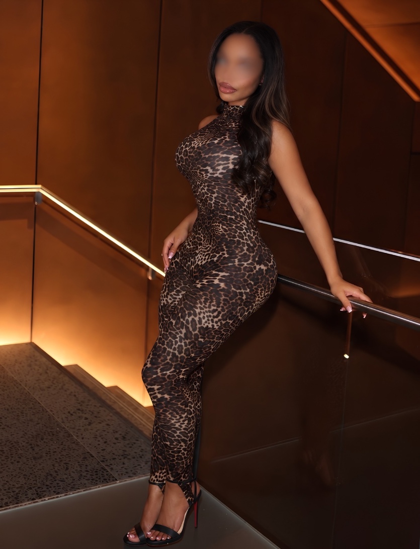 Milani in a leopard-print outfit beside a staircase